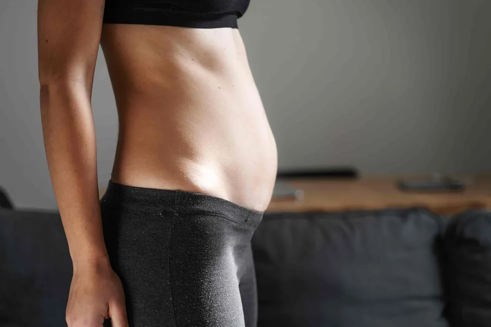Mulher com barriga inchada e desconforto abdominal